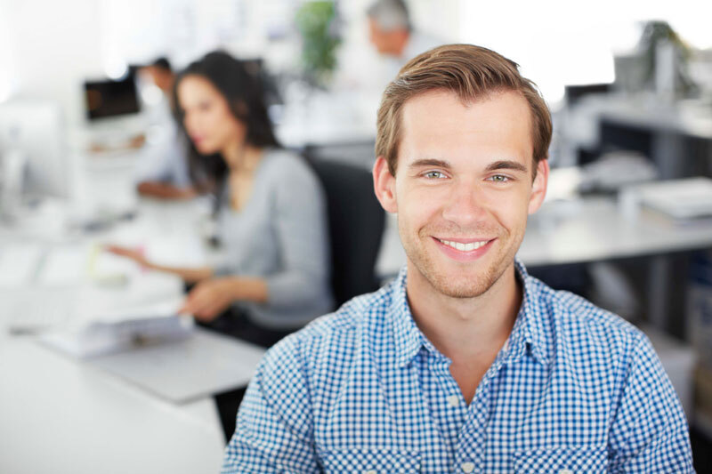 Smiling man in button up shirt with checkered pattern.