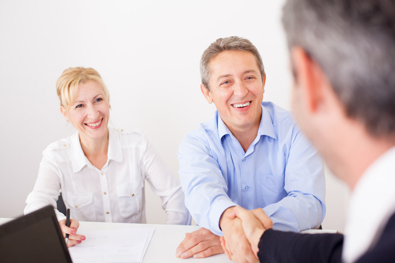 Woman and man meeting with another man. Men shake hands.